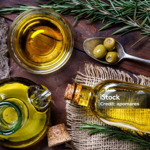 Top view of olives and olive oil bottles on table in a rustic kitchen Top view of olives and olive oil bottles on table in a rustic kitchen